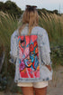Light blue denim jacket with a rough finish and artwork of a woman&