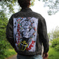 Black denim jacket featuring a striking black-and-white painting of the Sailor Man on the back, with magazine clippings for added texture.