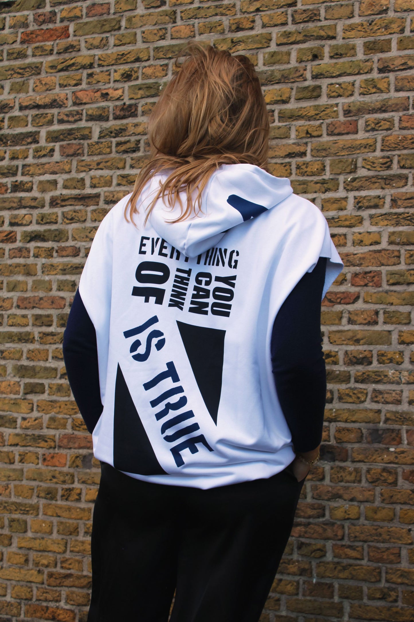 Oversized hoodie with bold text elements and artistic graphics, emphasizing a distinct streetwear look.