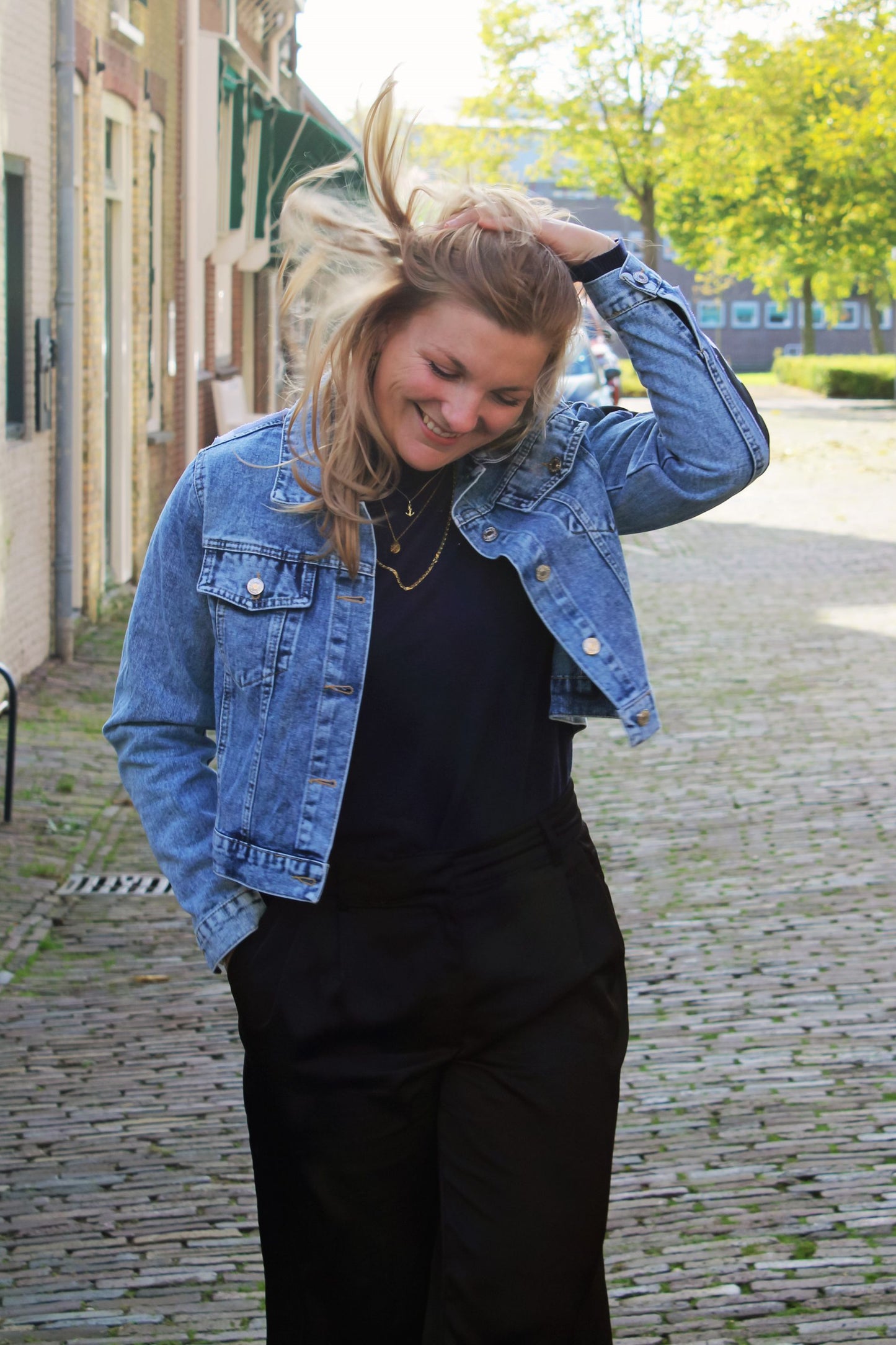 Light blue cropped denim jacket with abstract black-and-white panels, featuring bold lines and shapes