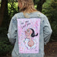 Light blue denim jacket with a colorful painting of Olive Oyl on the back against a pink background.