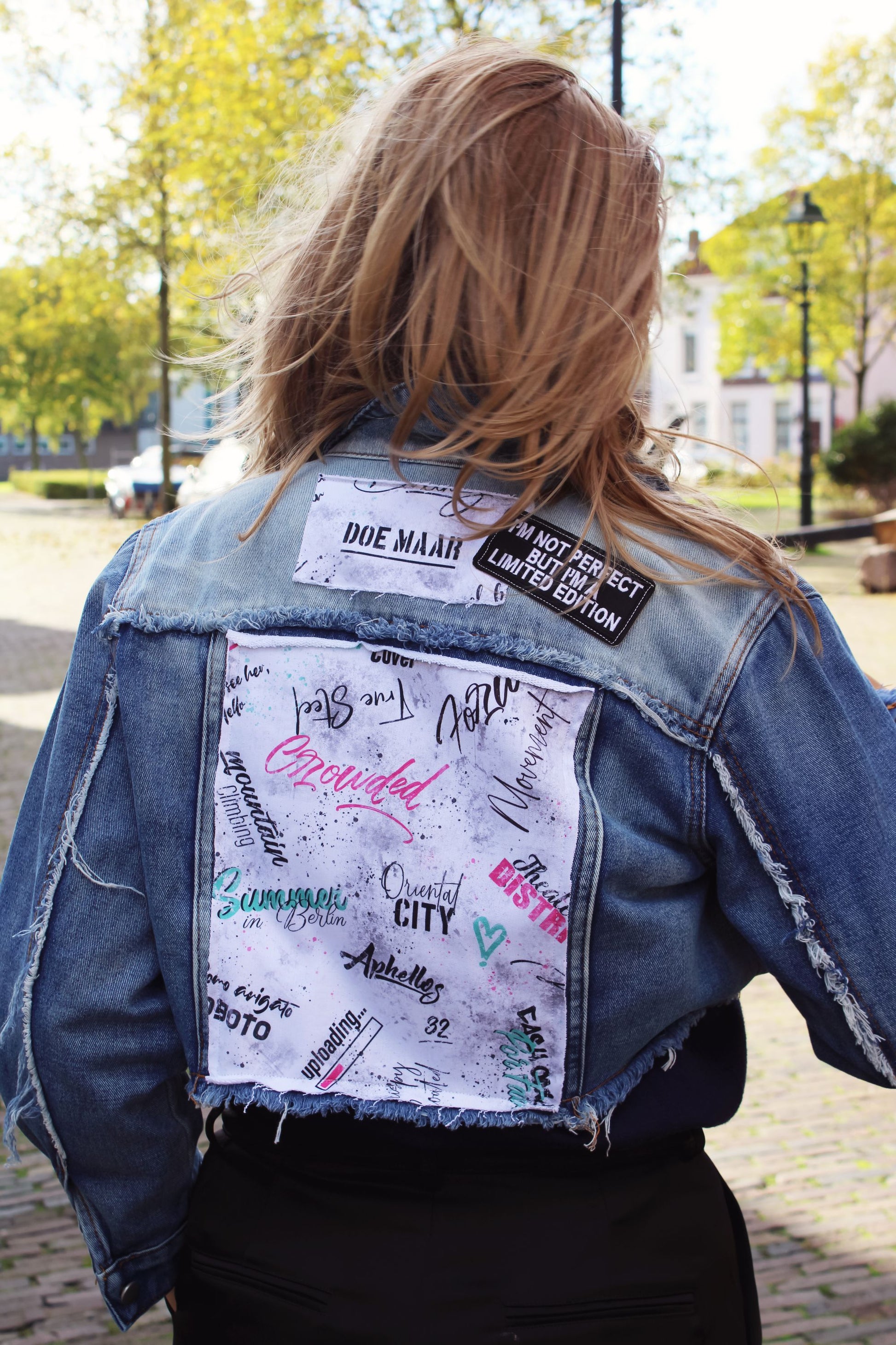 Casual yet edgy light blue denim jacket with soft text panels and a relaxed fit, perfect for street-style outfits.