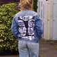 Wearable art jean jacket with a relaxed fit, textured details, and a striking face design.