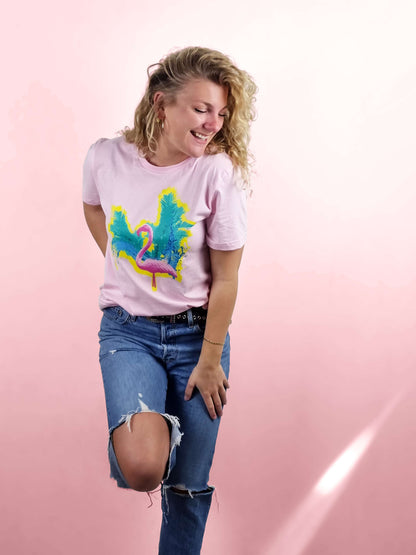 A pink salmon coloured t shirt with a vibrant tropical flamingo print design made of 100% cotton