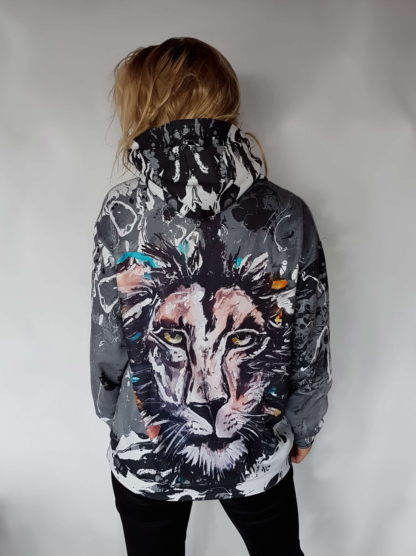 a black and white hoodie with a big picture of a lion on the back and an abstract print